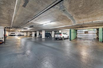 A car is parked in a large, empty parking garage.