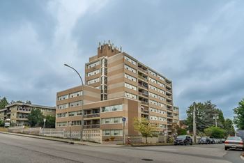 A large apartment building with a parking lot in front.