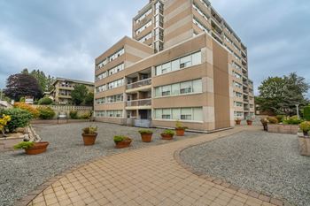 A multi-story building with a courtyard in front.