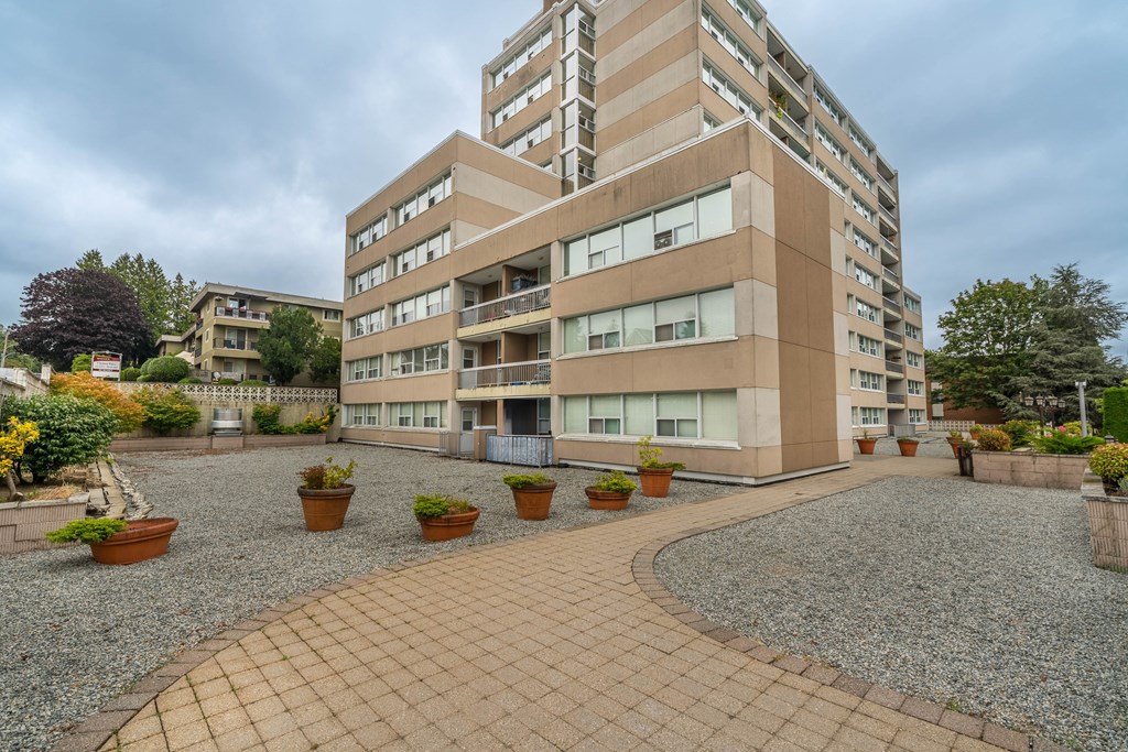 A multi-story building with a courtyard in front.