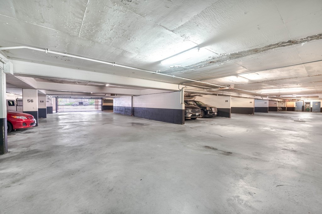 A parking garage with a red car parked in the first bay.