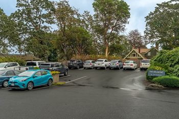 A parking lot with cars and a sign that says "The Belmont".