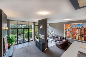 A living room with a large painting on the wall and a view of a cityscape.