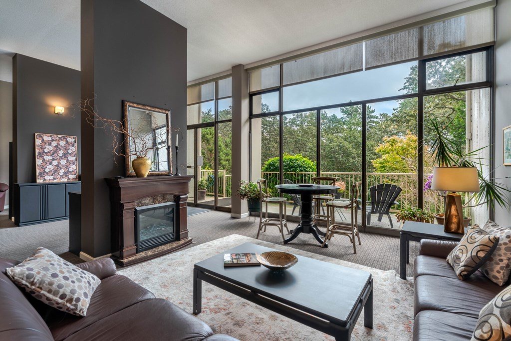 A living room with a fireplace and a glass table.