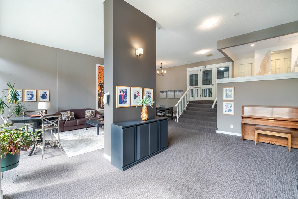 A living room with a dark blue cabinet and a staircase.