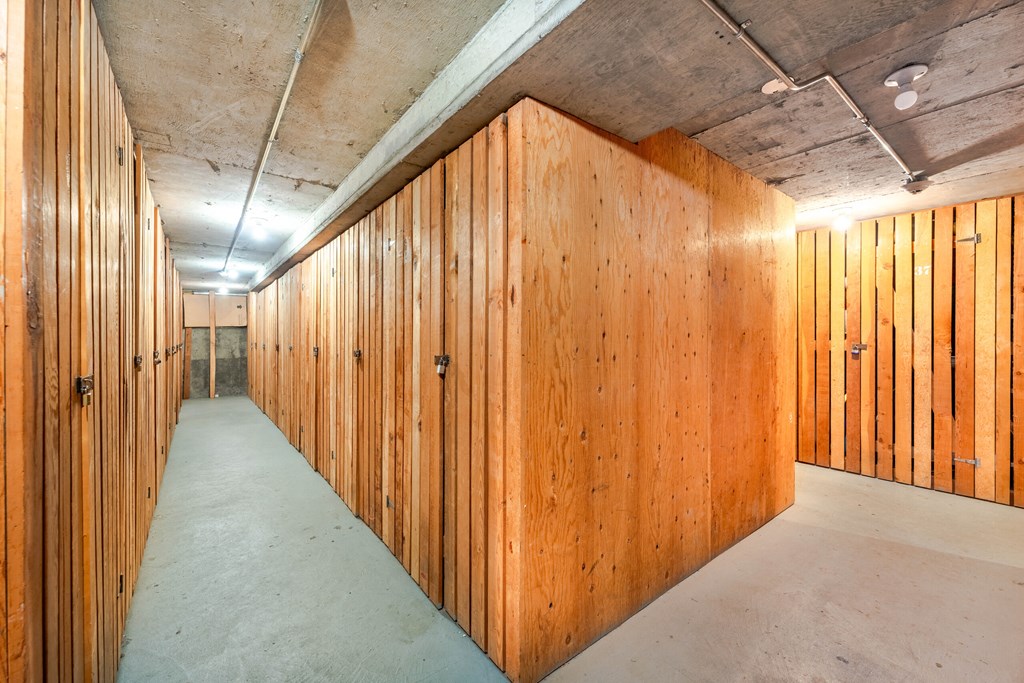 A long hallway with wooden walls and doors on both sides.