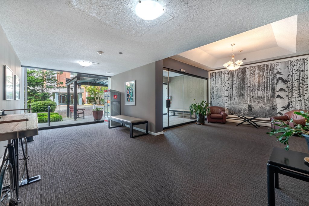 A room with a carpeted floor and a large painting on the wall.