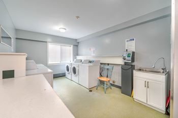 A laundry room with a washer and dryer, a sink, and a washing machine.