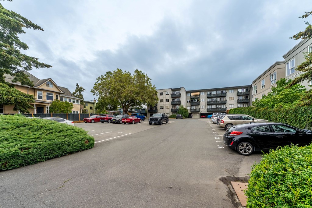 A parking lot with cars and apartment buildings in the background.