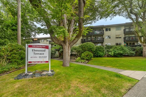 A sign for Elmwood Terrace stands in front of a building.