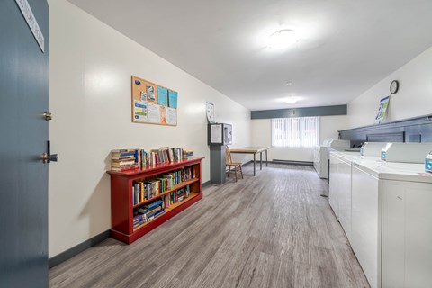 A room with a red bookshelf and a white cabinet.