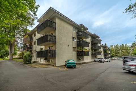 A car is parked in a parking lot in front of a building.