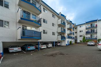 A parking lot with cars and apartment buildings.