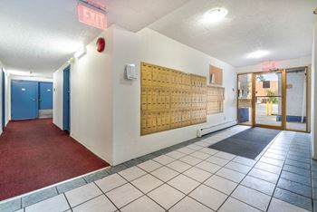 A hallway with a red exit sign above the door.