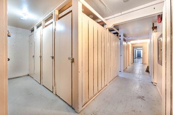A long hallway with wooden doors on both sides.