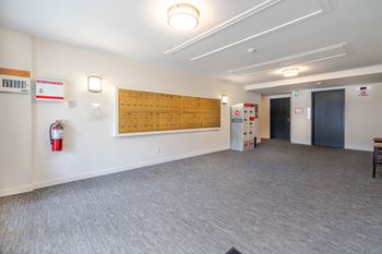 A room with a fire extinguisher on the wall and a wooden board on the wall.