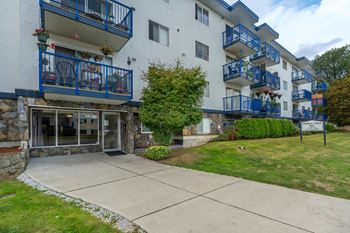 A white building with blue railings and a balcony.