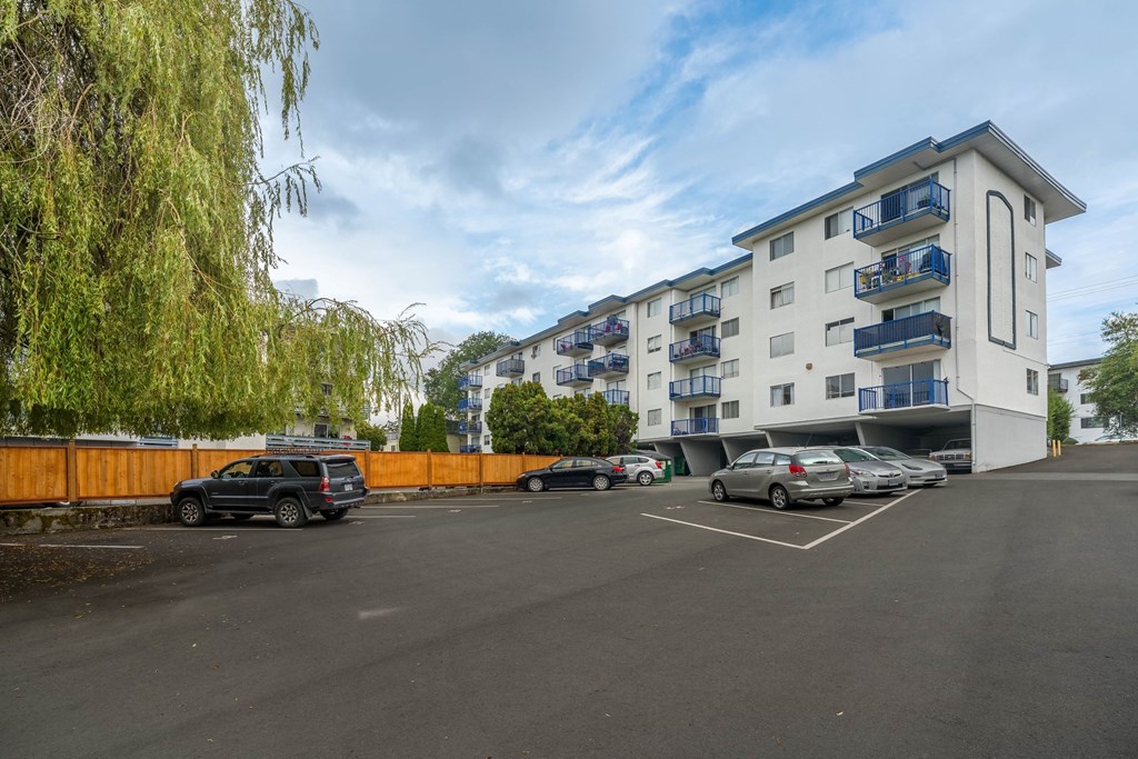 A parking lot with cars and a building in the background.