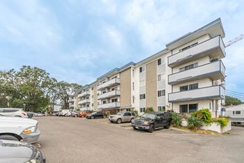 A parking lot with cars and a building in the background.