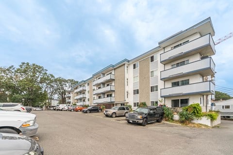 A parking lot with cars and a building in the background.