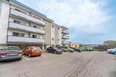 A parking lot with cars and apartment buildings in the background.