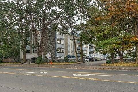 A street with a crosswalk and a sign on the sidewalk.