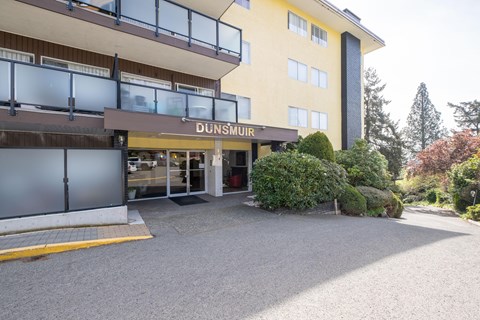 A yellow building with a glass entrance and a sign that reads "DUNSMUIR".