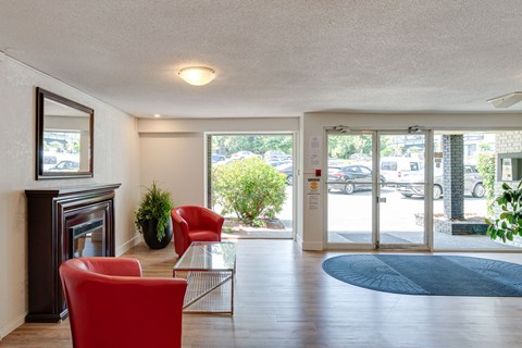 A living room with a fireplace and a red chair.