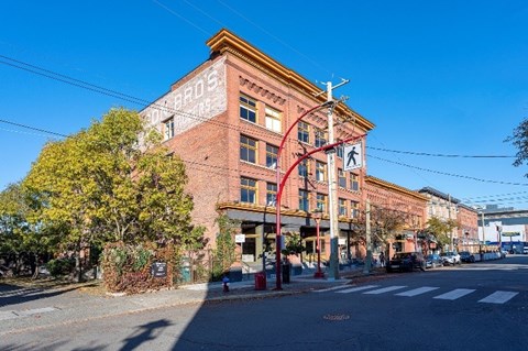 A street view of a red brick building with a clear blue sky.