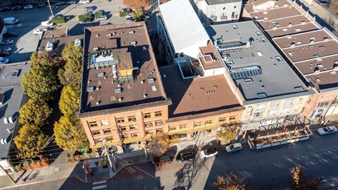 An aerial view of a city street with a large building in the center.