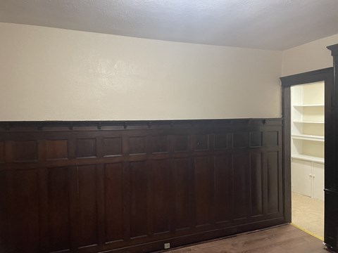 A brown wooden door with a white wall behind it.