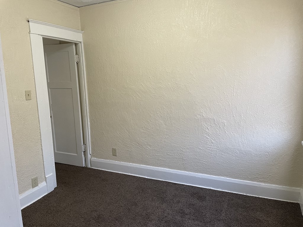 a room with a carpeted floor and a door
