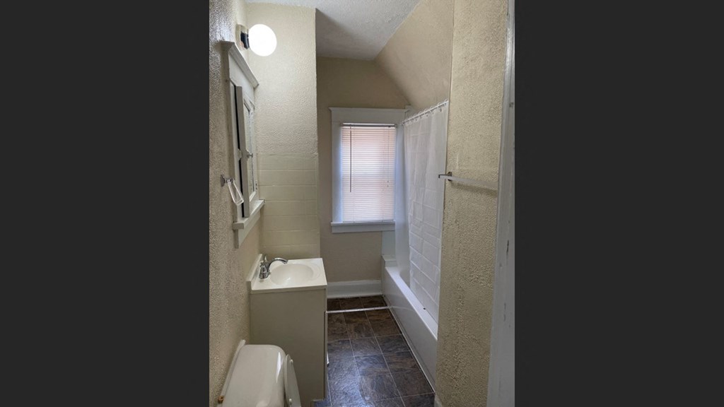 a bathroom with a sink and a toilet and a window