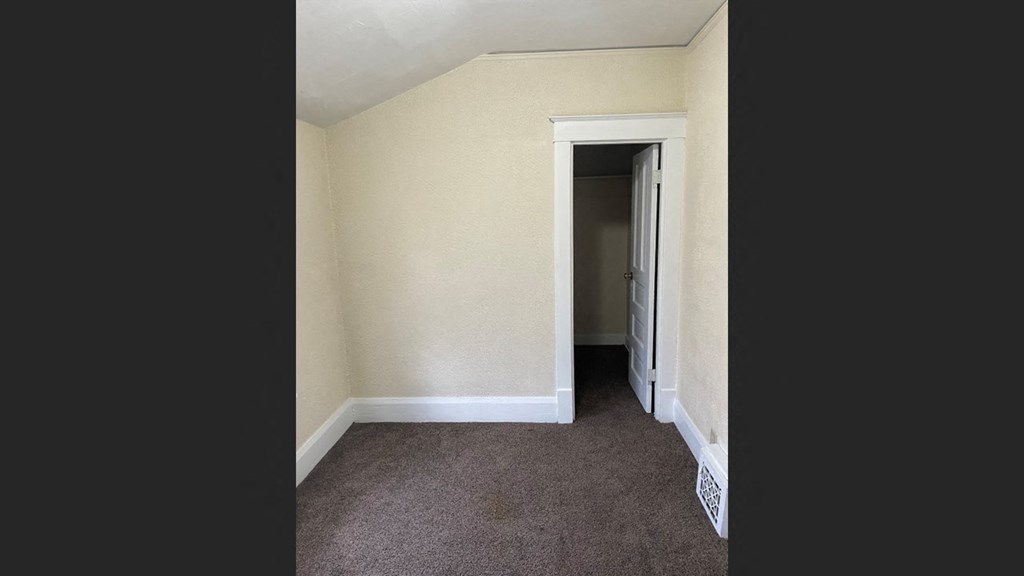 a bedroom with a closet and a door to a hallway