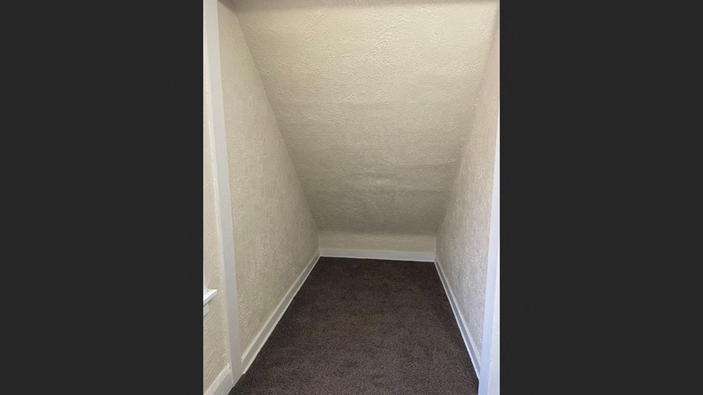 a small room with a brown carpet and a white wall