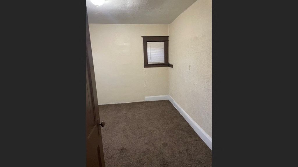 an empty room with a door and a window