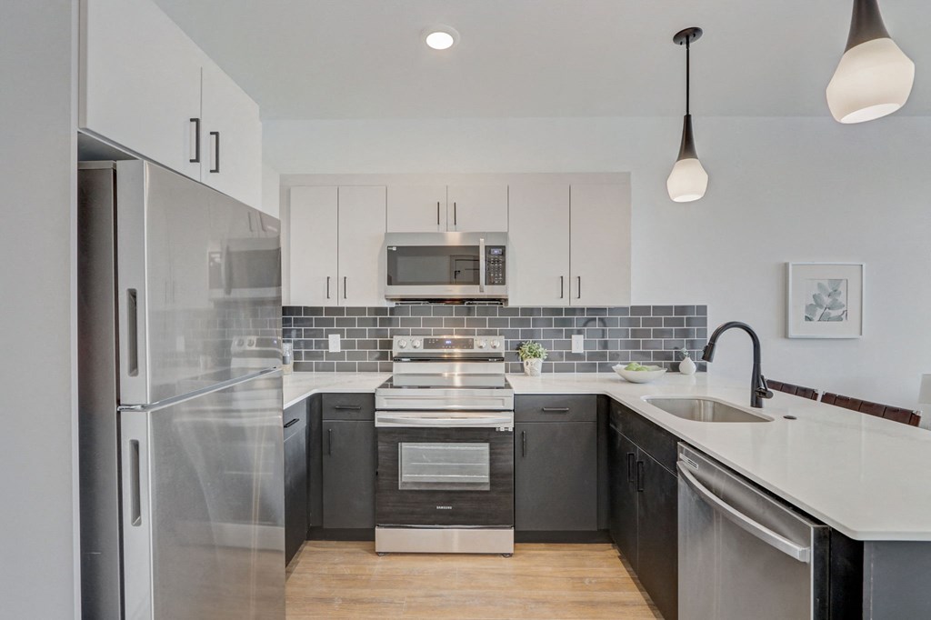 a modern kitchen with stainless steel appliances and white cabinets