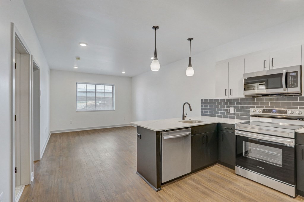 an empty kitchen with an island and stainless steel appliances