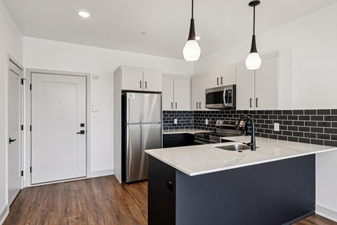 A kitchen with a white counter top and black cabinets.