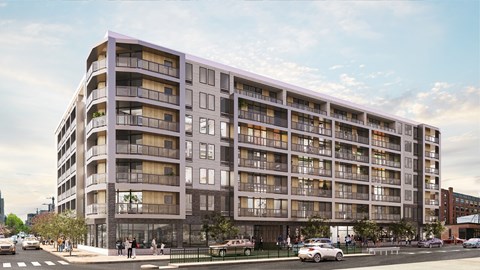 A large, modern apartment building with balconies and multiple stories.