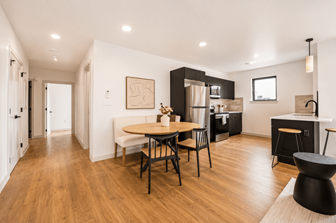A modern kitchen with a dining table and chairs.