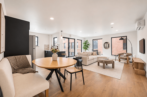 A modern living room with a wooden table and white couch.