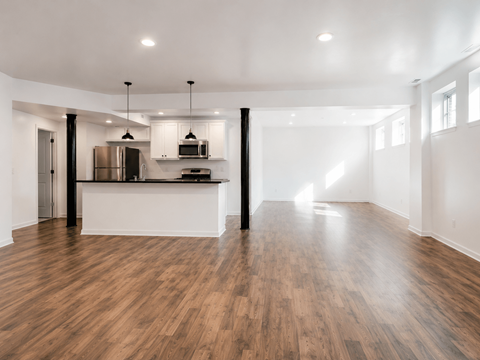 A kitchen with a refrigerator, microwave, and oven.