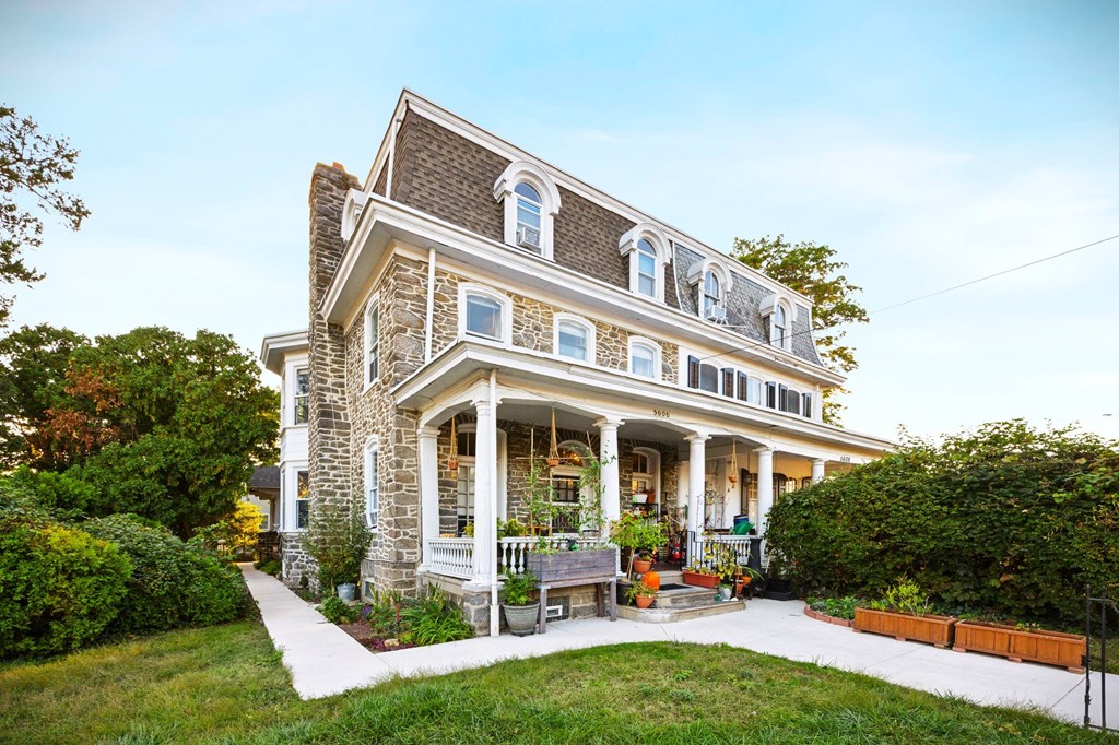 a large brick house with a porch and a lawn