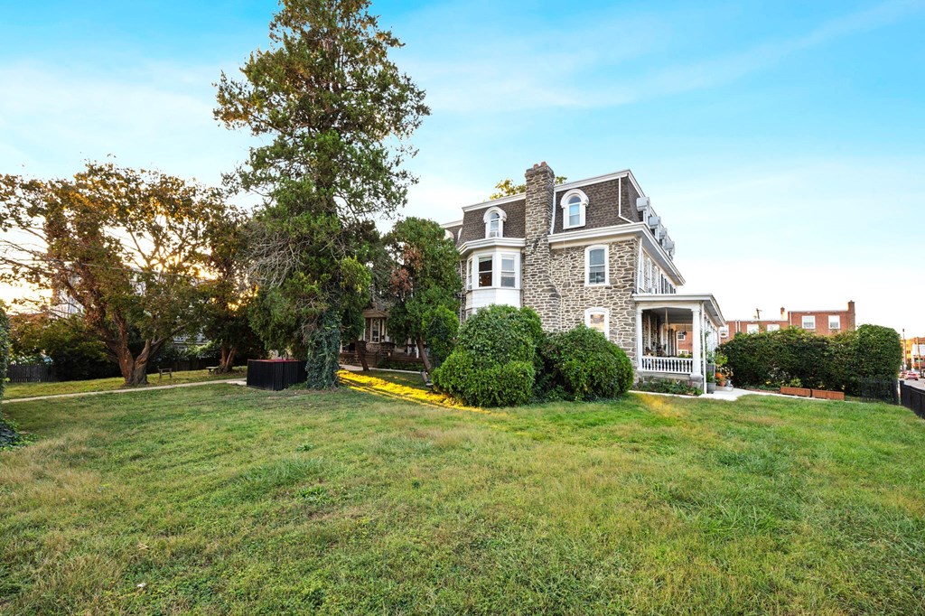 a house with a lawn and a tree in front of it