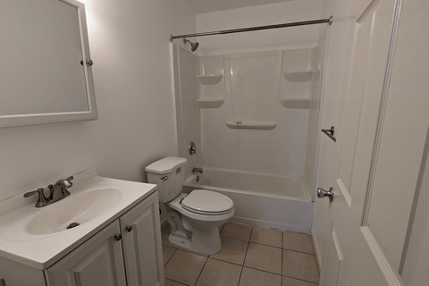 an empty bathroom with a sink toilet and shower