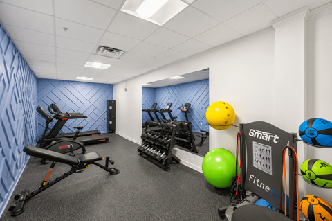 A gym with a row of exercise bikes, a green exercise ball, and a sign that says "smart fitness".