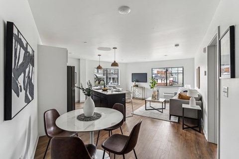 A modern dining room with a white table and brown chairs.