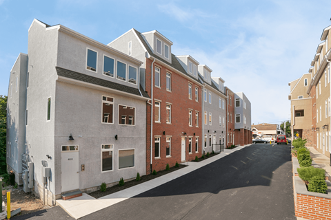 A row of townhouses with a car parked on the street.