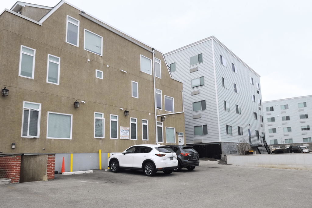 an apartment building with two cars parked in front of it